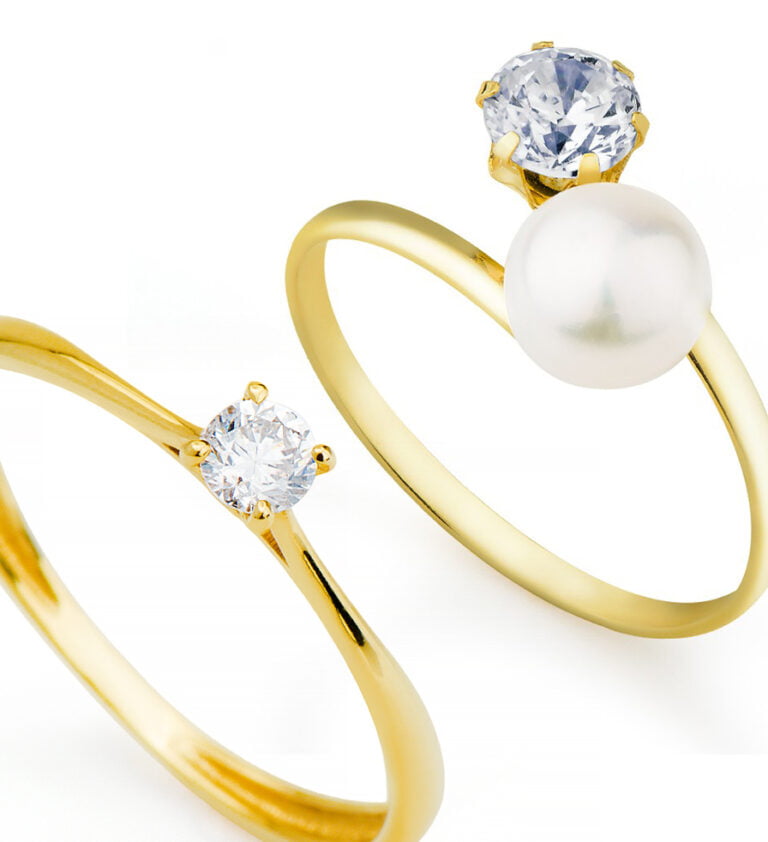 Uma aliança com um ponto de diamante e uma com um diamante e uma pérola.