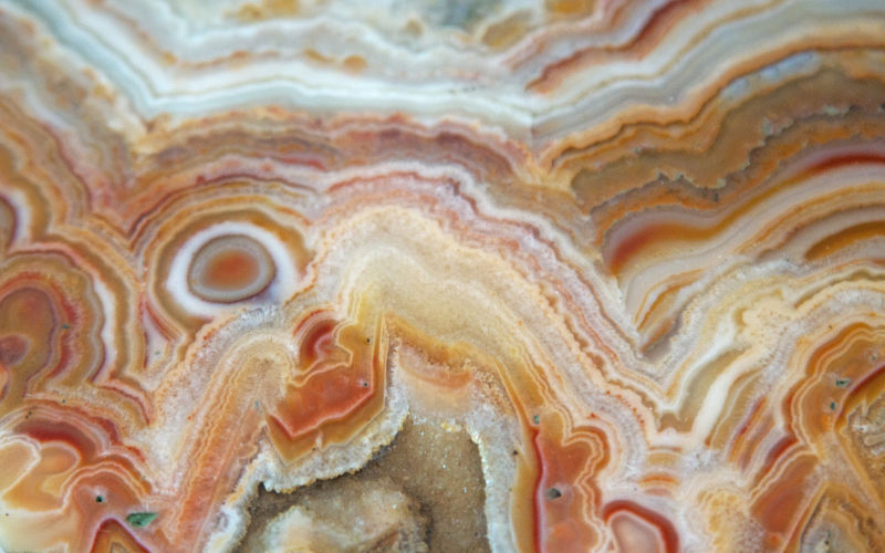 Vista de frente de pedras semipreciosas em laranja e branco chamadas de agata